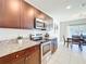 Contemporary kitchen with stainless steel appliances, granite countertops, and dark wood cabinetry at 3279 Landing Vw, Tavares, FL 32778