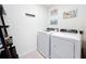 Bright laundry room with modern appliances, unique decor, and tile flooring at 3279 Landing Vw, Tavares, FL 32778