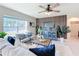 Cozy living room with a ceiling fan, neutral decor, and natural light from large windows at 3279 Landing Vw, Tavares, FL 32778