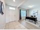 Inviting office space with a large window, wood floors and a white front door allowing natural light to fill the room at 3279 Landing Vw, Tavares, FL 32778