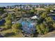 Aerial view of the community pool featuring palm trees, lounge chairs, and manicured landscaping near the water at 3279 Landing Vw, Tavares, FL 32778