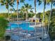 Aerial view of the community pool with lounge chairs and shaded pavilion, framed by palm trees at 3279 Landing Vw, Tavares, FL 32778