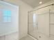 Shower with glass doors and white wall. Window shown looking out over the backyard at 3279 Landing Vw, Tavares, FL 32778