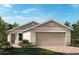 Charming one-story home featuring a two-car garage, neutral color palette and meticulously landscaped front yard at 3340 Rolling Hills Cir, Clermont, FL 34714