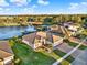 Aerial view showcases a well-maintained home with lush green lawn and water views, complemented by a brick driveway at 3707 Paradiso Cir, Kissimmee, FL 34746