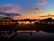 Waterfront homes with docks in community with colorful sunset reflected on lake at 3707 Paradiso Cir, Kissimmee, FL 34746