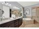 Elegant bathroom featuring double sinks, a large soaking tub, and a glass enclosed shower at 3707 Paradiso Cir, Kissimmee, FL 34746