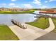 Scenic view of a boat ramp leading into a calm lake, with a covered dock and grassy shoreline at 3707 Paradiso Cir, Kissimmee, FL 34746