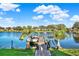 Private dock on the lake features a boat lift, American flag, and tropical palm trees at 3707 Paradiso Cir, Kissimmee, FL 34746
