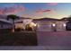 Charming home exterior with a brick driveway, a perfectly manicured lawn, and an attached garage at 3707 Paradiso Cir, Kissimmee, FL 34746