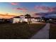 Inviting home exterior featuring a well-manicured lawn and a warm, welcoming ambiance at twilight at 3707 Paradiso Cir, Kissimmee, FL 34746