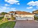 Beautiful single-story home with a tile roof, three-car garage and well manicured lawn and brick driveway at 3707 Paradiso Cir, Kissimmee, FL 34746