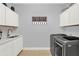 Well-lit laundry room features modern washer/dryer, cabinets, sink, and stylish decor at 3707 Paradiso Cir, Kissimmee, FL 34746