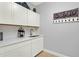 Clean and modern laundry room with white cabinets, quartz countertops, and decorative decor at 3707 Paradiso Cir, Kissimmee, FL 34746