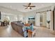 Open living room featuring tile floors, modern ceiling fan, and sliding barn door to bathroom at 3707 Paradiso Cir, Kissimmee, FL 34746