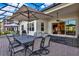Screened outdoor patio features a large dining table, comfortable seating, and a ceiling fan for relaxing and dining at 3707 Paradiso Cir, Kissimmee, FL 34746