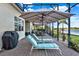 The covered outdoor patio features lounge chairs and shade with beautiful water views for ultimate relaxation at 3707 Paradiso Cir, Kissimmee, FL 34746