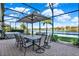 Covered lanai offering panoramic water views, outdoor dining, and a hot tub at 3707 Paradiso Cir, Kissimmee, FL 34746