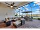 Spacious screened patio with comfortable seating, a fire pit, and tranquil water views at 3707 Paradiso Cir, Kissimmee, FL 34746