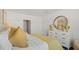 A light-filled bedroom shows bed with gold pillows, a white dresser and decor, for a clean and inviting space at 3739 Bluethread Way, Poinciana, FL 34759