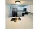 Modern kitchen with stainless steel appliances, white cabinetry, and a stylish gold faucet at 4100 Player Cir # 101, Orlando, FL 32808