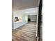 Spacious living room with wood floors, a wall mirror, and a glimpse of the modern kitchen at 4100 Player Cir # 101, Orlando, FL 32808