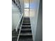Staircase with laminated steps and modern black railings, leading to the upper level at 4100 Player Cir # 101, Orlando, FL 32808