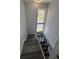 Staircase with laminated steps and modern black railings, leading to the lower level at 4100 Player Cir # 101, Orlando, FL 32808