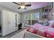 Bedroom featuring a large window, white wardrobe, ceiling fan, and pink bedding at 4321 Iveyglen Ave, Orlando, FL 32826