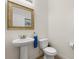 Bathroom featuring a pedestal sink, toilet, and a decorative mirror at 4822 Lake Milly Dr, Orlando, FL 32839