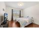 Bedroom with wood flooring, a queen bed, and a large window for ample natural light at 4822 Lake Milly Dr, Orlando, FL 32839
