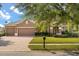 Charming two-story home featuring a three-car garage, lush lawn, and garden at 4822 Lake Milly Dr, Orlando, FL 32839
