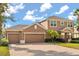Charming two-story home featuring a three-car garage and brick-paved driveway at 4822 Lake Milly Dr, Orlando, FL 32839