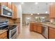 Modern kitchen features stainless steel appliances and granite countertops with wooden cabinets and island seating at 4822 Lake Milly Dr, Orlando, FL 32839