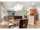 Open concept living area with modern light fixture, kitchen bar, and comfortable seating area with wall mounted TV at 4822 Lake Milly Dr, Orlando, FL 32839