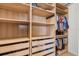 Walk-in closet with custom wooden shelving and ample storage space at 4822 Lake Milly Dr, Orlando, FL 32839