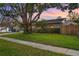 This single-story home features a well-manicured lawn, mature trees, and a charming exterior at 4991 Tangerine Ave, Winter Park, FL 32792