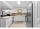 Modern kitchen with white cabinets, stainless steel appliances, granite countertops, and stylish tile flooring at 4991 Tangerine Ave, Winter Park, FL 32792