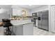 Eat-in kitchen featuring white cabinets, stainless steel appliances, granite countertops, tile flooring, and a breakfast bar at 4991 Tangerine Ave, Winter Park, FL 32792