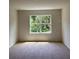 Cozy bedroom with neutral carpet and a large window showcasing lush greenery at 509 Coronado Cove Rd, New Smyrna Beach, FL 32168