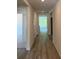 A bright hallway features wood floors and leads to rooms with views of the outdoors at 509 Coronado Cove Rd, New Smyrna Beach, FL 32168