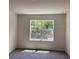 A neutral bedroom with a large window and plush carpet at 511 Coronado Cove Rd, New Smyrna Beach, FL 32168