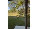 Backyard showcasing serene green space with mature trees, visible through a sliding glass door at 512 Coronado Cove Rd, New Smyrna Beach, FL 32168