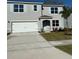 Charming two-story home with blue shutters, a two-car garage, and a well-maintained front yard at 512 Coronado Cove Rd, New Smyrna Beach, FL 32168
