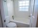 Bathroom features a white tiled tub/shower combo, toilet, and white walls with a window at 620 E Church St, Orlando, FL 32801