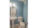 Small bathroom with pedestal sink, decorative mirror, and checkerboard tile floor at 620 E Church St, Orlando, FL 32801