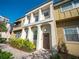 Attractive two-story townhome with light-colored exterior, arched entryway, and neatly landscaped front yard at 620 E Church St, Orlando, FL 32801