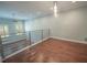 Open loft space with wood floors, recessed lighting, and a modern metal railing at 620 E Church St, Orlando, FL 32801