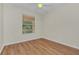 Cozy bedroom features hardwood floors and natural light from a large window at 6613 Duncaster St, Windermere, FL 34786