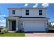 Two-story home featuring brick accents, an attached two-car garage, and a covered front entry at 7020 Rolling Leaf Dr, Groveland, FL 34736